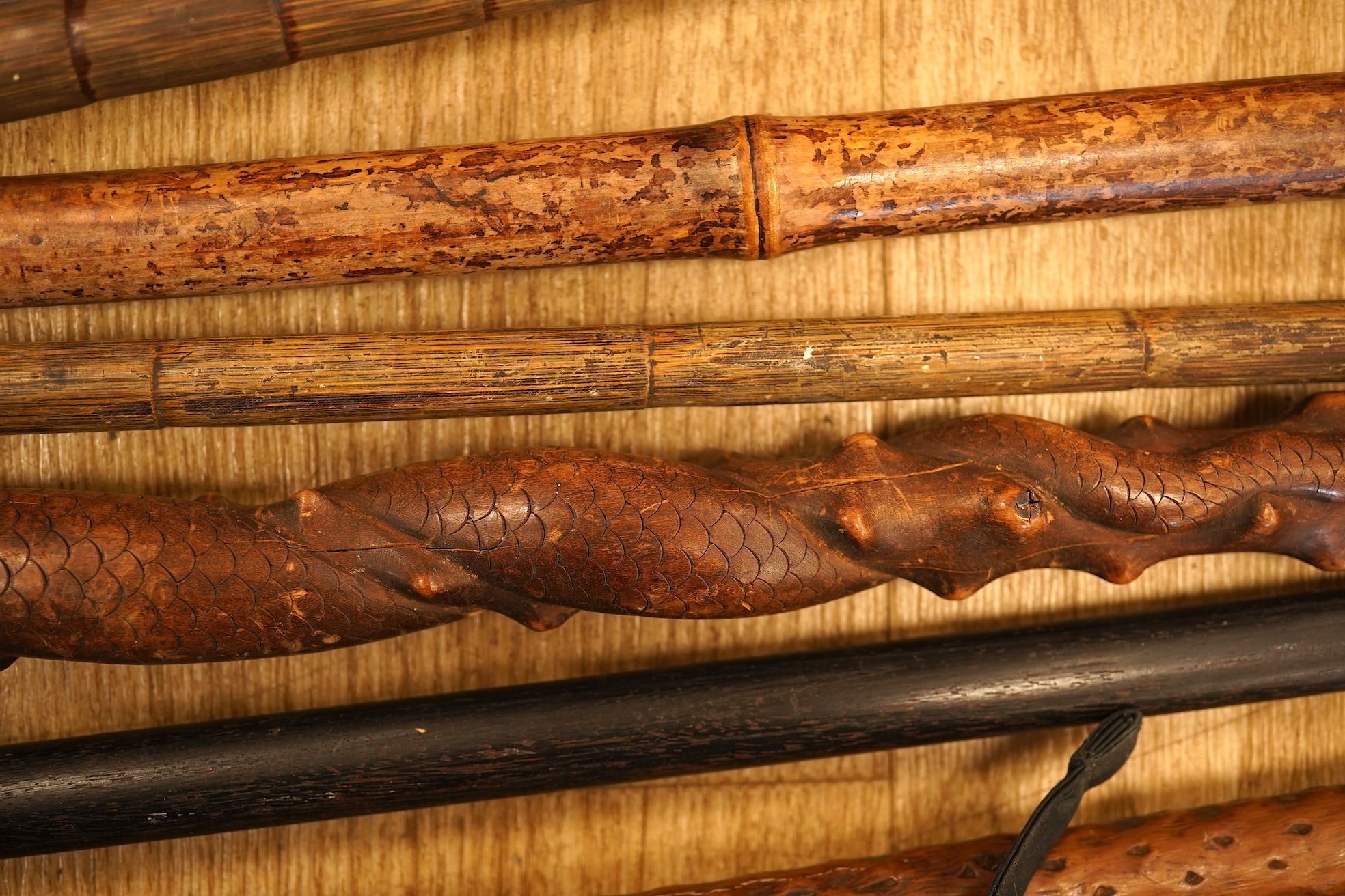 A collection of eleven carved walking sticks, some silver mounted